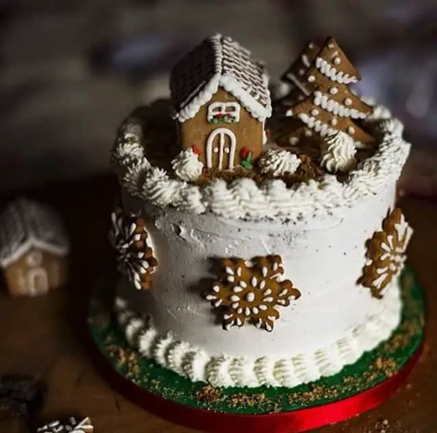 Mini gingerbread house on top of a cake