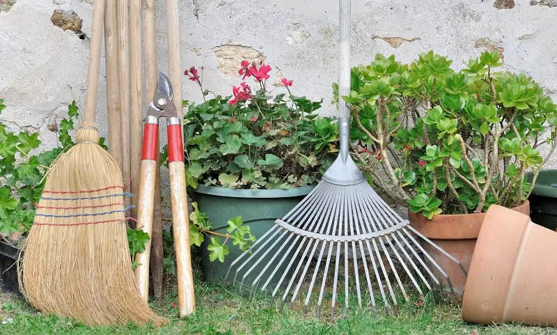 outils de jardinage et pots de fleurs dans un jardin Clean Up Your Garden